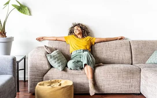 A person relaxing on a sofa in a comfortable living room