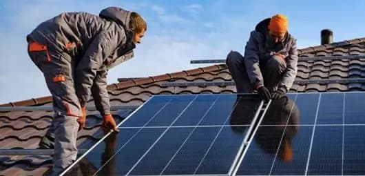 Installers working on a rooftop solar system.